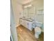 A bright bathroom features a double sink vanity, wood-look flooring, and a toilet at 345 S Forest St, Denver, CO 80246