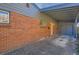 Side view of a brick home featuring a covered carport and a bright orange door at 345 S Forest St, Denver, CO 80246