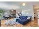 Open-concept living room with a brick fireplace, hardwood floors, and a comfortable blue sectional at 345 S Forest St, Denver, CO 80246