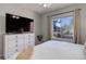 Comfortable bedroom with a dresser, television, and large window with natural light at 1671 W Canal Cir # 221, Littleton, CO 80120