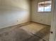 A basic bedroom featuring neutral carpet, a window with blinds, and a plain wall ready for new decor and personal touches at 8779 Santa Fe Dr, Thornton, CO 80260