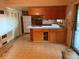An older kitchen featuring wood cabinets and dated appliances, needing renovation to modernize its appearance and functionality at 8779 Santa Fe Dr, Thornton, CO 80260