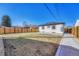 Backyard features a partial lawn, wood privacy fence, walkway, and white exterior elevation at 1328 Holly St, Denver, CO 80220