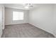 Spacious bedroom with soft carpet, ceiling fan, and a large window for natural light at 12555 Birch Ave, Thornton, CO 80241