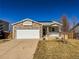 Charming home with a stone facade, white garage door, and a well-maintained front yard with mature landscaping at 12555 Birch Ave, Thornton, CO 80241