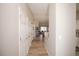 Bright hallway featuring wood floors and multiple closets, leading to an open living space at 12555 Birch Ave, Thornton, CO 80241