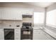 Bright kitchen with granite countertops, white cabinets, and stainless steel appliances providing a functional cooking space at 12555 Birch Ave, Thornton, CO 80241