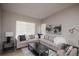 Bright living room features a neutral color scheme, plush sectional sofa, and large windows at 12555 Birch Ave, Thornton, CO 80241