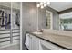 Contemporary bathroom featuring gray tile, white cabinets, and a closet for optimal storage at 1192 S Fultondale Cir, Aurora, CO 80018
