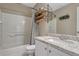 Neutral bathroom featuring a shower-tub combo, granite vanity, and stylish overhead shelving at 1192 S Fultondale Cir, Aurora, CO 80018