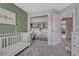 Cozy Bedroom with a crib, decorative wall art, and closet with shelving for storage at 1192 S Fultondale Cir, Aurora, CO 80018