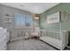 Charming Bedroom featuring an accent wall, a rocking chair, and a crib near a window at 1192 S Fultondale Cir, Aurora, CO 80018