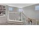 This upper-level landing features an open staircase with white railings and plenty of natural light at 1192 S Fultondale Cir, Aurora, CO 80018