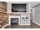 Close up view of a living room fireplace with a TV above and decorative shelving at 1192 S Fultondale Cir, Aurora, CO 80018