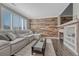 Inviting living room with a gray sectional sofa, wood accent wall, and a modern fireplace at 1192 S Fultondale Cir, Aurora, CO 80018