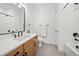 Stylish bathroom with a wood vanity, modern fixtures, white quartz countertop, and a shower-tub combination at 331 Josef Cir, Fort Lupton, CO 80621