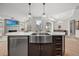 Island with stainless sink, quartz countertops, and stainless dishwasher and views of living and dining areas at 331 Josef Cir, Fort Lupton, CO 80621