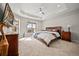 Spacious bedroom with tray ceiling, ceiling fan, and large windows at 331 Josef Cir, Fort Lupton, CO 80621