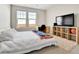 This bedroom features natural light, a desk, a TV, and a soft shag rug at 13598 Via Varra # 301, Broomfield, CO 80020