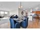 Bright dining area boasts a glass table, seating for four, and is adjacent to the modern kitchen with hardwood floors at 13598 Via Varra # 301, Broomfield, CO 80020