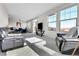 Spacious living room with large windows offering great views, comfortable leather seating, and plush carpeting at 13598 Via Varra # 301, Broomfield, CO 80020