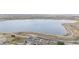 Scenic aerial view of a tranquil lake surrounded by walking trails near cozy homes at 649 Mockingbird St, Brighton, CO 80601