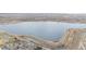 Scenic aerial view of a tranquil lake surrounded by walking trails near cozy homes at 649 Mockingbird St, Brighton, CO 80601