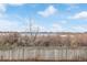 Picturesque view of a tranquil lake and surrounding natural scenery visible beyond a backyard fence at 649 Mockingbird St, Brighton, CO 80601