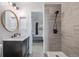 A bathroom featuring a dark wood vanity, a shower, and gray tile surround at 649 Mockingbird St, Brighton, CO 80601