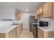 An open concept kitchen with stainless steel appliances, and light wood cabinets at 649 Mockingbird St, Brighton, CO 80601