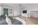 Bright living room features hardwood floors, a comfortable gray sofa and a television on a dresser at 649 Mockingbird St, Brighton, CO 80601