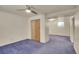 The basement features neutral walls, blue carpet, a ceiling fan, and a wood closet door at 5510 Troy St, Denver, CO 80239