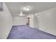 Large basement living area with blue carpet, white walls, and recessed lighting fixtures at 5510 Troy St, Denver, CO 80239