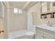 Bathroom features a shower, white vanity, modern fixtures, and natural lighting at 5510 Troy St, Denver, CO 80239