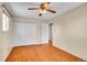 The empty bedroom features hardwood floors, a ceiling fan, and a large closet with white doors at 5510 Troy St, Denver, CO 80239