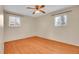 An empty bedroom features hardwood floors, large windows, and a ceiling fan with light at 5510 Troy St, Denver, CO 80239