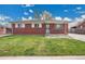 Charming brick home featuring a well-maintained lawn and classic design elements under a bright sky at 5510 Troy St, Denver, CO 80239