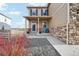 Charming front porch of a home with stone accents, colorful flowers and seating at 2042 Shadow Creek Dr, Castle Rock, CO 80104