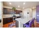 Bright kitchen with stainless steel appliances, dark cabinets, and a spacious island with seating at 2042 Shadow Creek Dr, Castle Rock, CO 80104