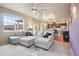 Bright open-concept living room with a large sectional sofa, adjacent to the dining area and kitchen at 2042 Shadow Creek Dr, Castle Rock, CO 80104