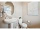 Cozy powder room featuring modern fixtures, pedestal sink, and decorative mirror at 2042 Shadow Creek Dr, Castle Rock, CO 80104