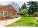 Landscaped backyard featuring a brick house, a stone walkway, and lots of greenery at 3756 S Forest Way, Denver, CO 80237