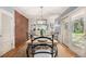 Sunny dining room with backyard access, a contemporary light fixture, brick wall and hardwood floors at 3756 S Forest Way, Denver, CO 80237