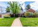 Charming brick home featuring a well-manicured lawn, mature trees, and a welcoming walkway to the front door at 3756 S Forest Way, Denver, CO 80237