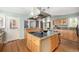 Spacious kitchen features stainless hood, island cooktop and breakfast bar with barstool seating at 3756 S Forest Way, Denver, CO 80237