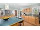 Bright kitchen offers island seating, wood cabinets, modern pendant lights, and hardwood floor at 3756 S Forest Way, Denver, CO 80237