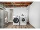Basement laundry room features new washer and dryer with exposed wood ceiling at 3756 S Forest Way, Denver, CO 80237