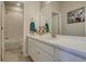 Bathroom with a white vanity, framed mirror, and tub with tile surround at 14445 Hop Clover Trl, Parker, CO 80134