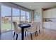 Modern dining room with large windows overlooking a backyard with grass and a fence at 14445 Hop Clover Trl, Parker, CO 80134