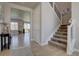 Bright foyer showcasing hardwood floors, stairs, and an open view into the living and dining areas at 14445 Hop Clover Trl, Parker, CO 80134